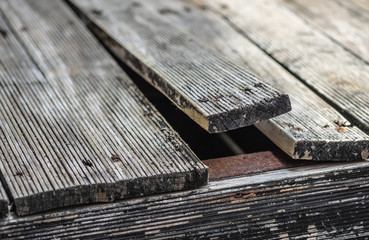 Exterior pine wooden floor bending due to Climate Change, front focus blurred background