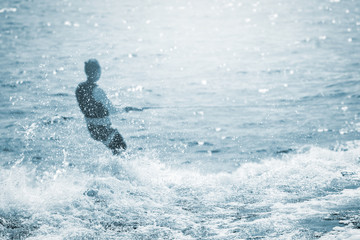 unscharfer wasserski sportler vor scharfer wasserwelle
