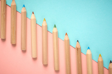 Wooden color pencils on blue background, flat lay