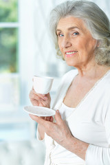 Portrait of beautiful smiling senior woman drinking tea