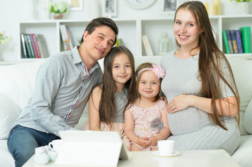 Portrait of happy pregnant woman with husband and daughters