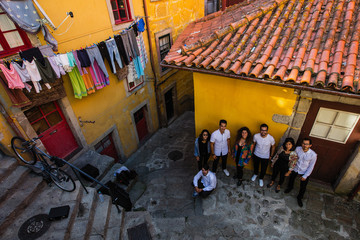 Company of young people on a narrow street of the old city. Porto^ Portugal.