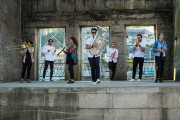 Group of Jazz musicians with wind instruments playing on the street.