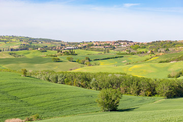 View of a rolling landscape with a village on a hill