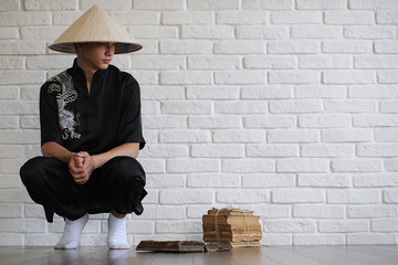 Asian young novice on a white brick wall