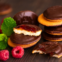 Jaffa cakes, cookies covered with dark chocolate and filled with raspberry marmalade. Sweet background.