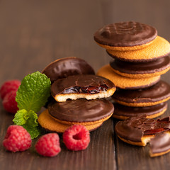 Jaffa cakes, cookies covered with dark chocolate and filled with raspberry marmalade. Sweet background.
