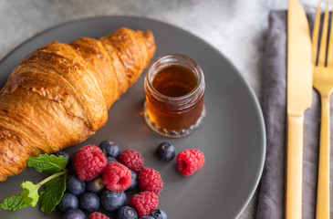 French croissant  served with  fresh berries and syrup. Continental breakfast in the hotel background. Good morning concept.