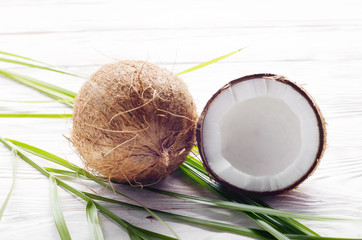 Coconut and shell pieces on white wooden table
