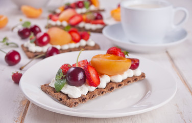 Crisp bread with creme cheese, fruit and berries