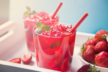 Glasses with fresh homemade strawberry sweet iced tea or cocktail, lemonade with mint. Refreshing cold drink. Summer pool party. Marine theme.