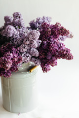 Perfect violet bouquet of lilac flowers in a stylish vase on a white background