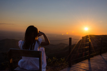 Criança reflexiva ao entardecer com por do sol