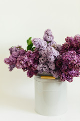Perfect violet bouquet of lilac flowers in a stylish vase on a white background