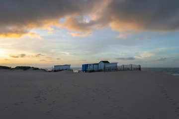 Coucher de soleil orange, bleu, gris color&eacute; sur une plage de sable, bateau &agrave; l'horizon. C&ocirc;ted'opale