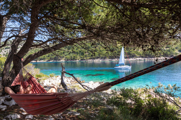 Woman relaxing in the hammock on a hot sunny day on the island lastovo, croatia