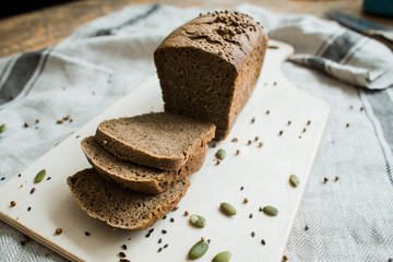 fresh sliced bread on a wooden board on a grey fabric