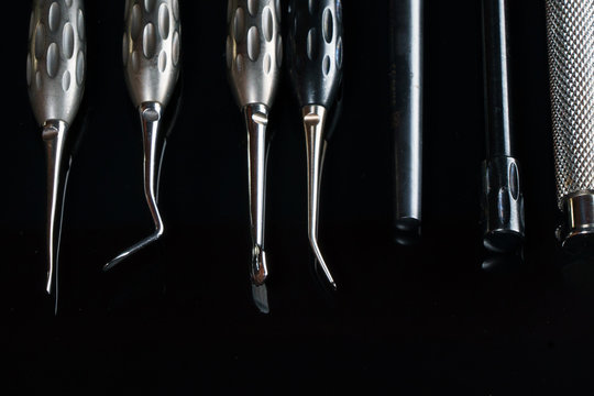 dental instruments for surgery and various manipulations, shot on black glass with reflection