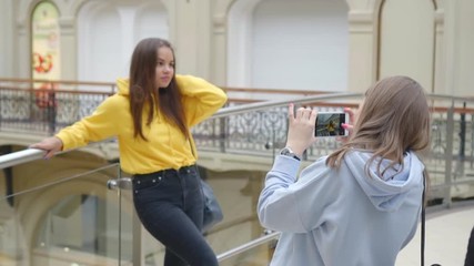 one friend poses to another for photo,lifestyle portrait of young positive woman