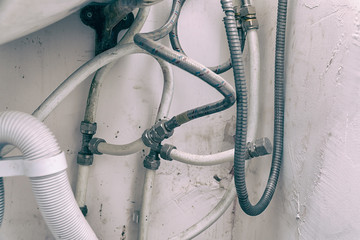 Old dirty sink with wrong connection of pipes and other plumbing
