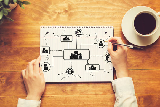 Social connections theme with a person writing in a notebook on a wooden table