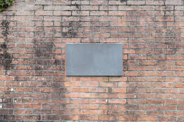 Blank iron house number plate on brick wall with weathered and stained texture background.
