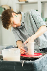 Pretty women working on the potter's wheel in the studio