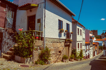Fototapeta na wymiar Old houses with flowering pots and deserted alley