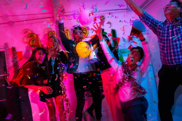Blurry People on a party in the nightclub.group of friends celebrate party and throwing confetti while enjoying home Young company celebrates birthday with a cocktail in hand.