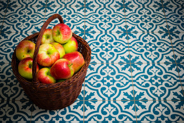basket of apple on kitchen tile floor, vignette frame