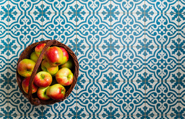basket of apple on kitchen tile floor