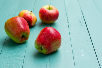 four apples on blue wooden background