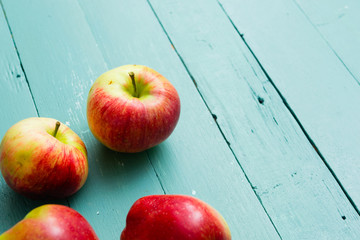 four apples on blue wooden background