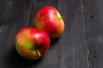 two apples on black wooden background