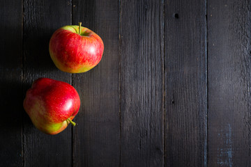 two apples on black wooden background