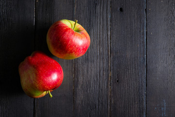 two apples on black wooden background