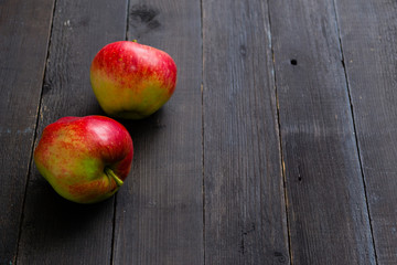 two apples on black wooden background