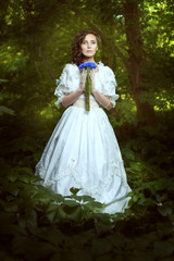 Obraz na płótnie Canvas Fantastic girl in a white dress with flowers cornflowers.