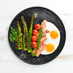 Breakfast. Asparagus, eggs, bacon and cherry tomatoes. Healthy food. Top view. Free space for your text.