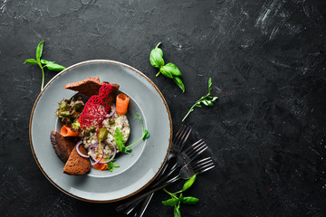 Herring tartar in a plate. Rustic style. Top view. Free space for your text.