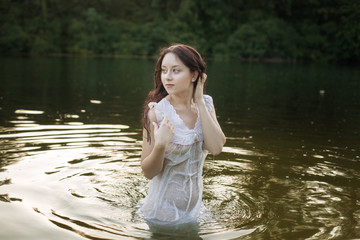 Portrait of a beautiful young woman in a lake.