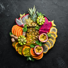 A plate of sliced tropical fruit. Top view. Free space for text.