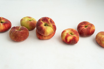Fresh peaches scattered on white painted background