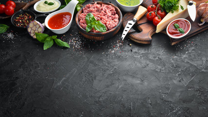 Ingredients for cooking sauce Bolognese. On a black background. Top view. Free space for your text.