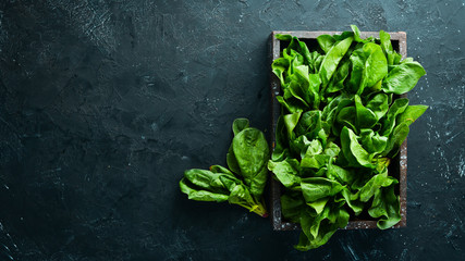 Spinach in a wooden box. Healthy food. Top view. Free space for your text.