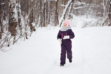 Fototapeta na wymiar Young girl in winter snowy forest.