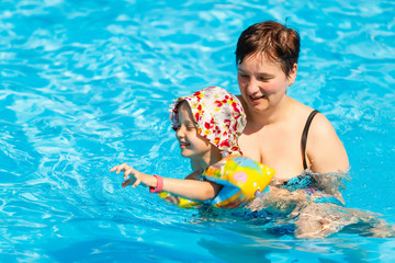 happy little girl and mother in pool