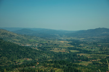 Naklejka premium Wooded valley with the roofs of a small village