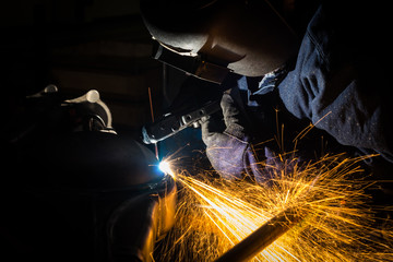 Workers are grooving with carbon welding wires With sparksWorkers are grooving with carbon welding...