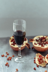 A wine glass with red wine stands on a gray grunge background next to grenades.